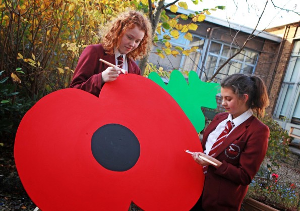 SEEING RED: Sarah Sharp, 13, and Chloe Toward, 13, paint a giant poppy. Picture: SARAH CALDECOTT