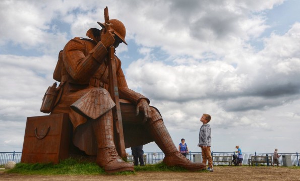 A young boy looks up at the imposing giant sculpture of "Tommy", the World War One soldier, which is set to remain on Seaham's seafront after a small community of residents raised £85,000 to keep the nine-foot sculpture